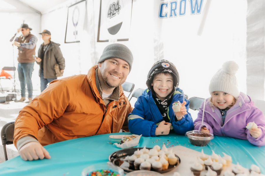 A family with kids smiling at a table in the AFA kids area